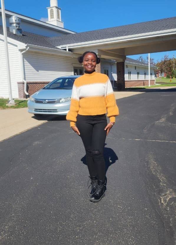 Photo of Emily wearing a yellow sweater